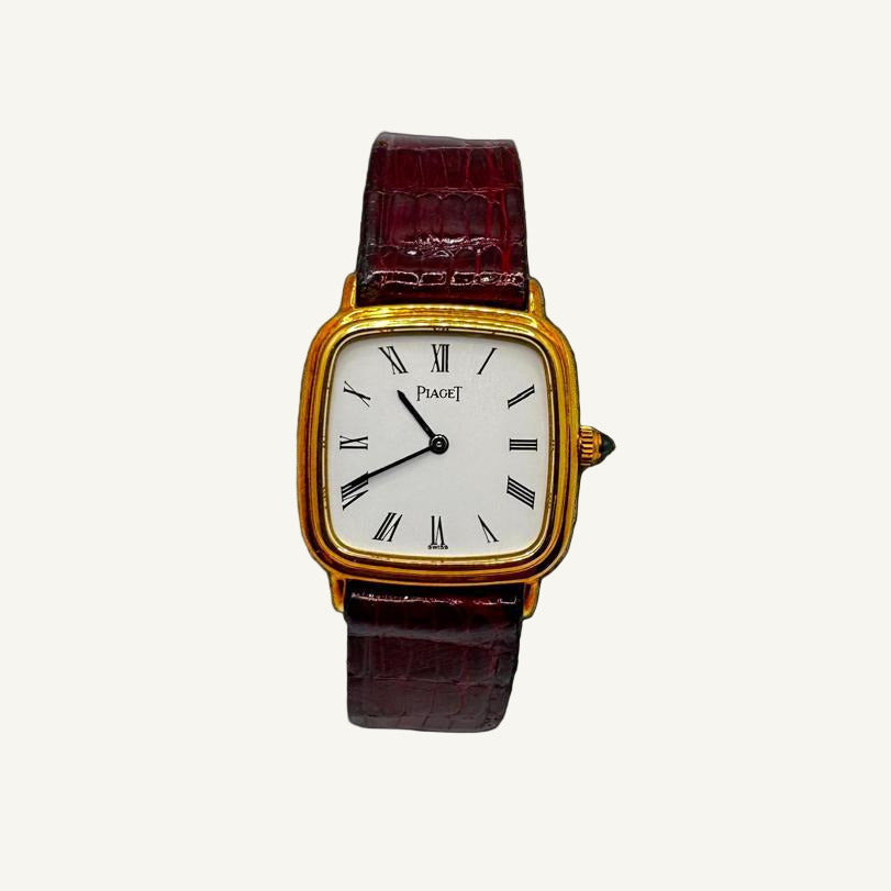 Vintage Piaget watch with a gold case and brown leather strap on a background